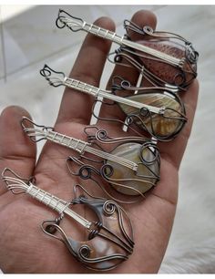 a person is holding several metal objects in their hand and they are all made out of wire