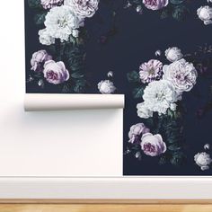 a wall with flowers on it and a roll of paper in front of the wall