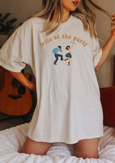 a woman standing on top of a bed wearing a t - shirt that says we are the party