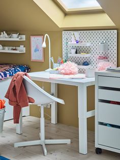 a white desk and chair in a small room with a skylight above the desk