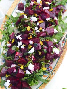 beet salad with goat cheese and arugula leaves on a colorful platter