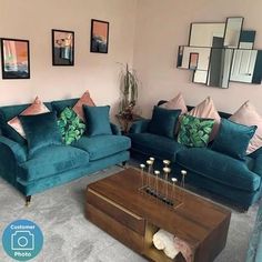 a living room filled with blue couches next to a coffee table and mirror on the wall