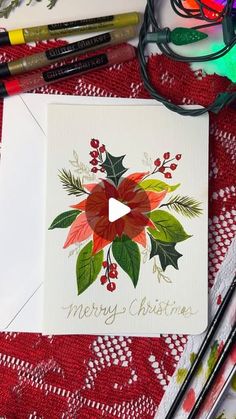 a christmas card sitting on top of a table next to crayons and markers