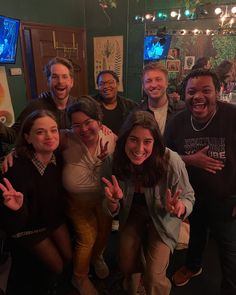 a group of people posing for a photo in front of a bar with lights on