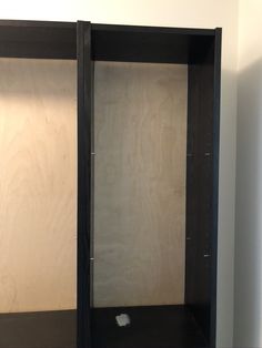 an empty black cabinet with no doors in a room