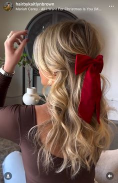 a woman with long blonde hair wearing a red bow