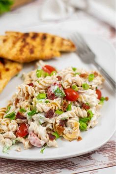 a white plate topped with pasta salad and chicken