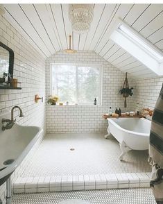 a bathroom with a tub, sink and window in the ceiling is white bricked walls