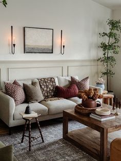 a living room with couches, tables and lamps on the wall above them is decorated in neutral colors