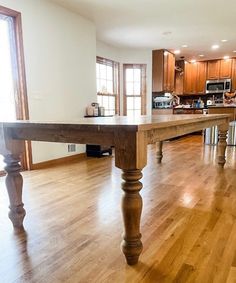 an empty kitchen and dining room with wooden floors