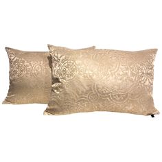 two gold pillows sitting next to each other