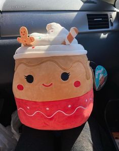 a stuffed toy in the back seat of a car with a cup on it's head