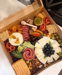 a box filled with different types of cheeses and crackers next to olives