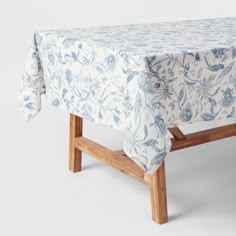 a blue and white table cloth on top of a wooden bench with a floral design