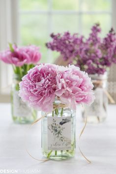 three vases filled with pink flowers on top of a table