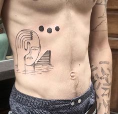 a man's chest with tattoos on it and an egyptian pyramid in the background