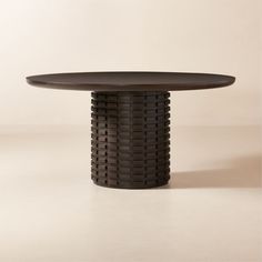 a round table with an intricate design on it's top and base, against a plain background