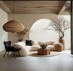 a living room filled with lots of furniture next to a round table and two vases