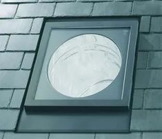 a window on the side of a brick building with a circular glass pane above it