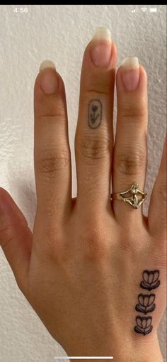 a woman's hand with a small tattoo on the middle finger and an arrow in the middle