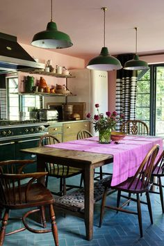 a kitchen with green cabinets and pink table cloth on the dining room's table