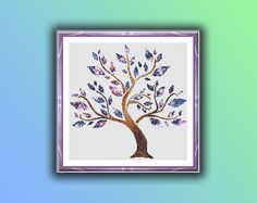 a cross - stitch tree with leaves on it is displayed in a purple frame against a blue and green background