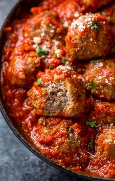 meatballs in marinara sauce with parmesan cheese on top, ready to be eaten