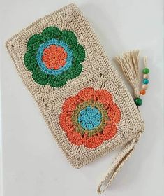 a crocheted pouch with tassels and beads next to it on a table