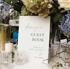 there is a sign that says guest book on the table next to flowers and candles