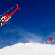 a helicopter is flying over a skier in the snow