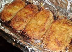 four fried meat patties sitting on top of tin foil