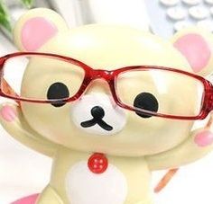 a small teddy bear wearing glasses on top of a desk