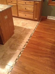 a kitchen with wooden cabinets and tile flooring