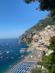 the beach is lined with boats and parked on it's sides next to the ocean