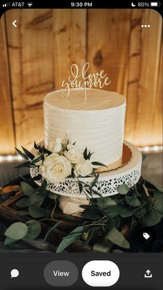 a wedding cake with white flowers and greenery