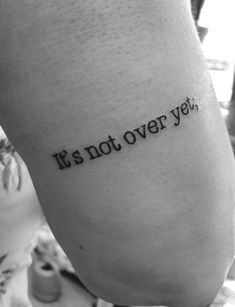 a person with a tattoo that says it's not over yet