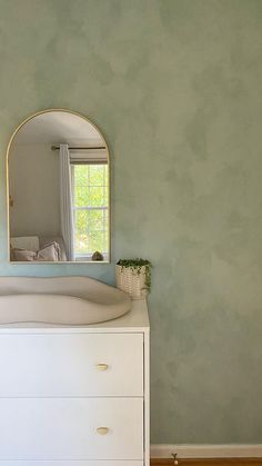 a white dresser with a mirror on top of it