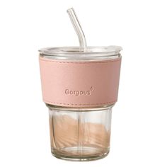 a glass cup with a straw in it and a pink leather strap around the bottom