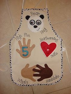 a child's bib with handprints on the front and five fingers on the back