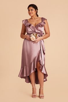 a woman in a purple dress holding a bouquet