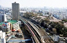 an aerial view of a city with tall buildings and train tracks in the foreground