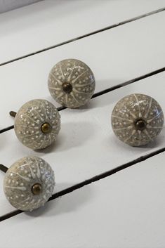 four glass knobs are sitting on a white table