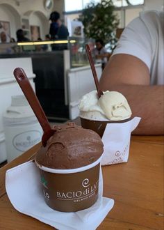 two ice creams in cups on a table