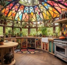 a kitchen with stained glass windows and lots of potted plants