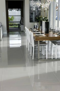 a dining room table with white chairs and flowers