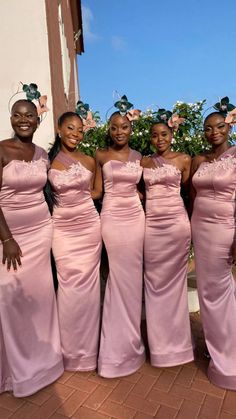 four women in pink dresses posing for the camera