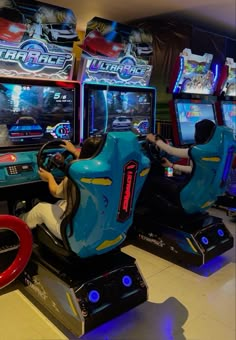 two people are playing video games in a game room with arcade machines and other gaming equipment