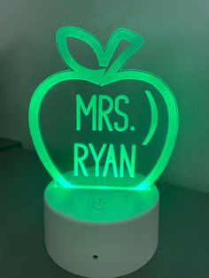 an apple shaped light up with the words mrs ryan on it's side, sitting on a table