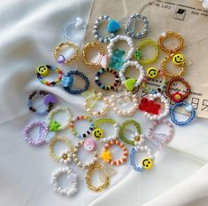 a bunch of bracelets that are laying on top of a white sheet and some paper