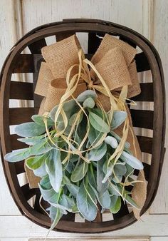 a bunch of green plants sitting on top of a wooden basket with burlocks